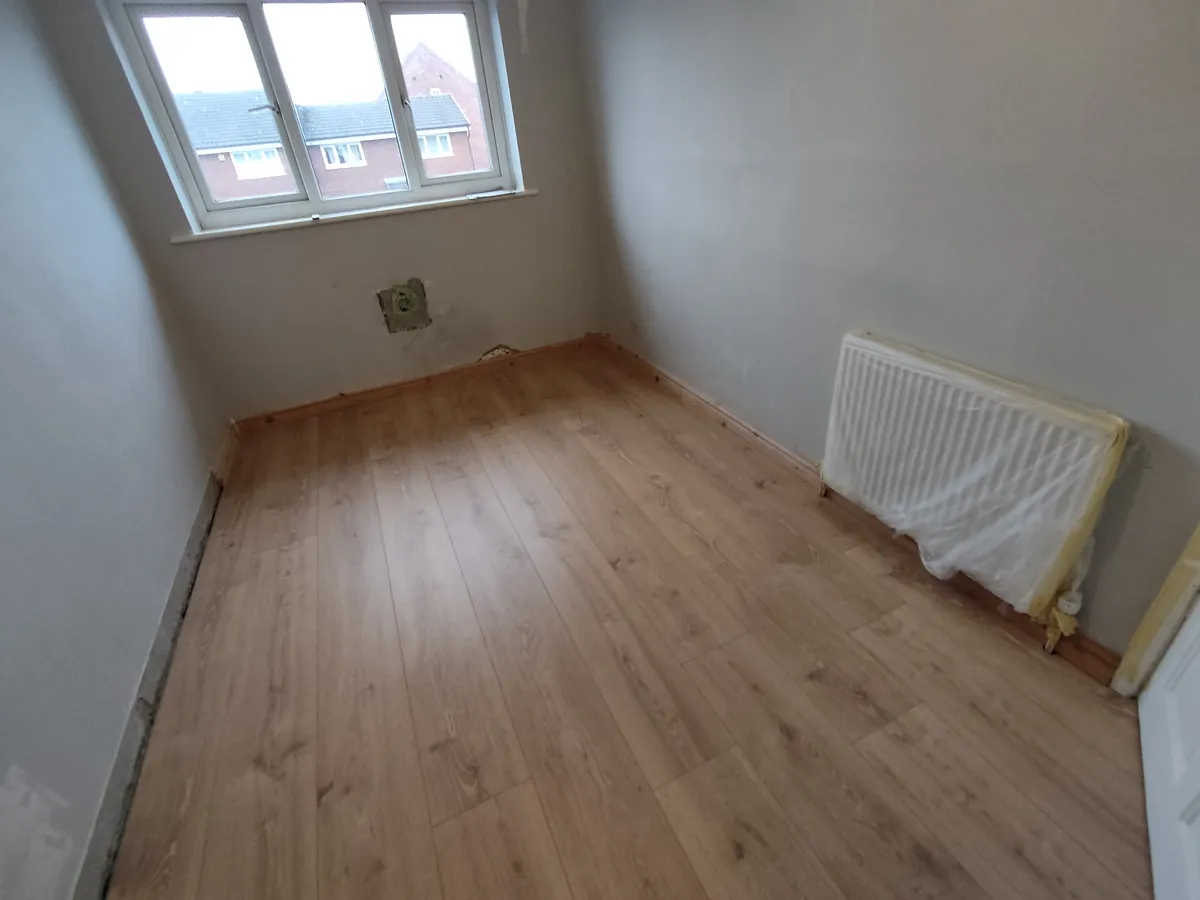 Laminate flooring cut neatly around a radiator in a bedroom