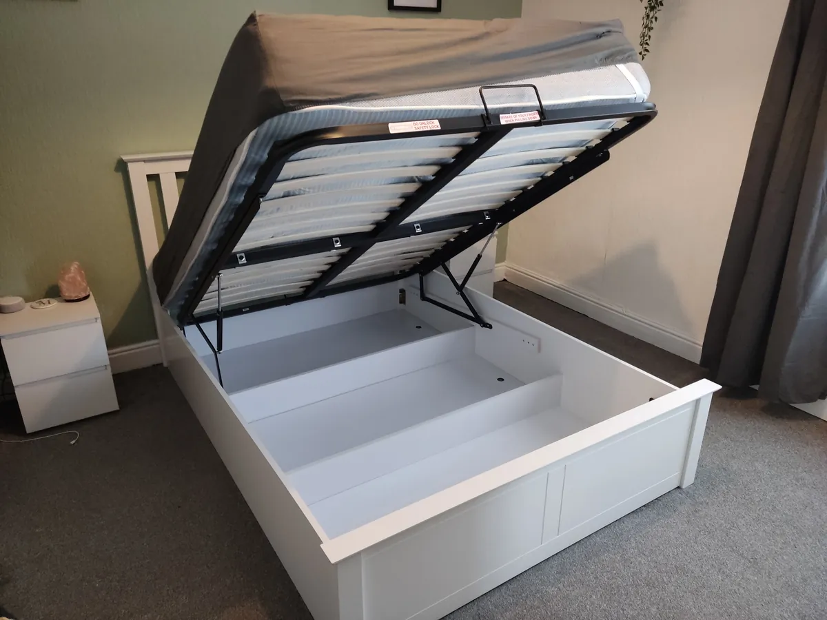 Assembled white ottoman storage bed with the gas-lift base raised