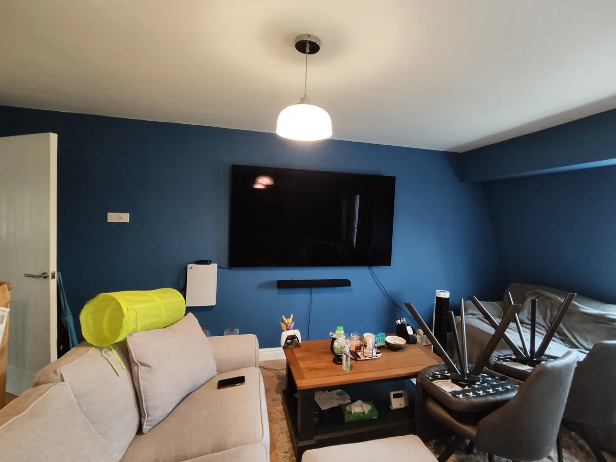 TV and soundbar wall-mounted on a deep blue feature wall